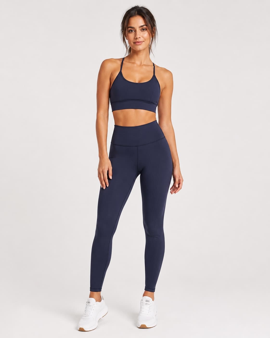 Model wearing the navy sports bra and high-waisted leggings